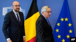 Belgian Prime Minister Charles Michel (L) walks European Commission President Jean-Claude Juncker prior to a meeting at EU headquarters in Brussels on March 16, 2018.
