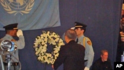 Secretary-General Ban Ki-moon faces flag that flew over UN mission in Haiti at memorial service in New York, 19 Jan 2010