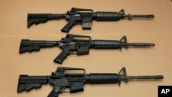 FILE -- Three variations of the AR-15 assault rifle are displayed in Sacramento, Calif. While the guns look similar, the bottom version is illegal in California because of its quick reload capabilities. Omar Mateen used an AR-15 that he purchased legally 