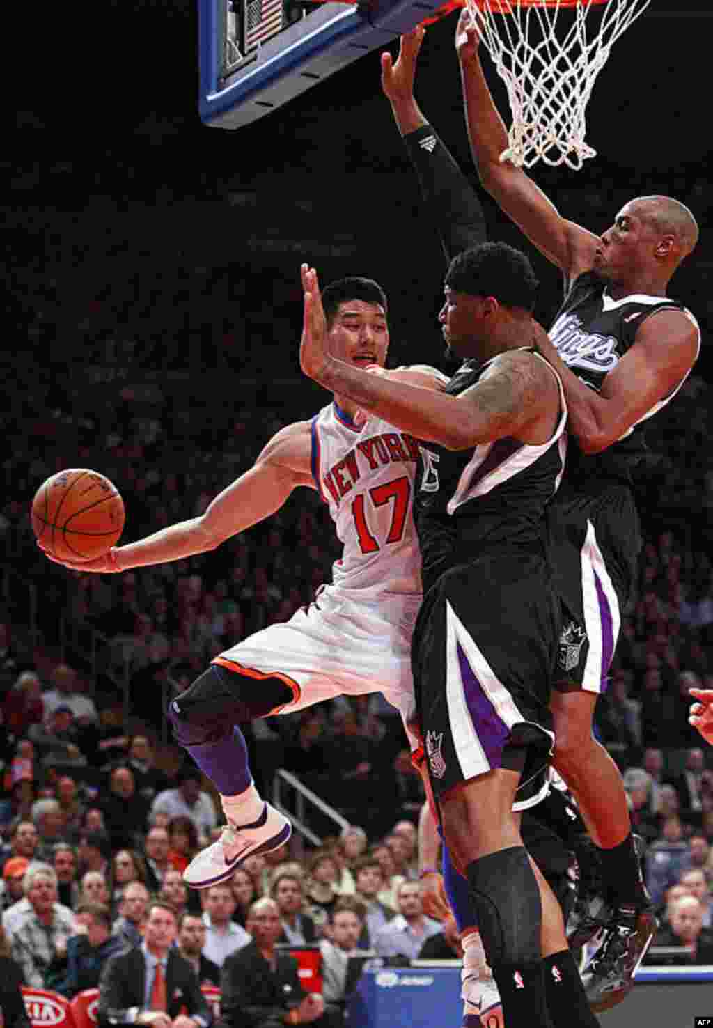 New York Knicks' Jeremy Lin passes away from Sacramento Kings' DeMarcus Cousins, center, and Travis Outlaw, right, during the first half of an NBA basketball game, February 15, 2012, in New York. (AP)