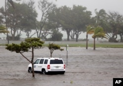 A park officer's vehicle sits in a flooded parking lot at Haulover Park as Hurricane Irma passes through the area, in North Miami Beach, Florida, Sept. 10, 2017.