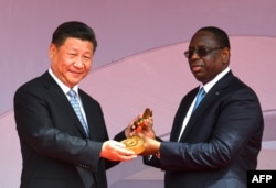 마키 살 세네갈 대통령이 22일 세네갈 수도 다카르의 경기장에서 시진핑 중국 국가주석에게 기념 열쇠를 건네고 있다.