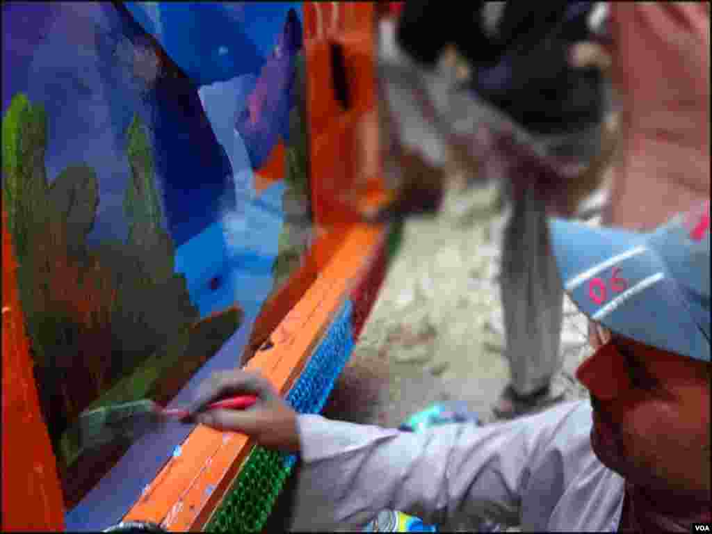 کراچی: ٹرک کے ورکشاپ میں ایک آرٹسٹ قدرتی مناظر بناتے ہوئے