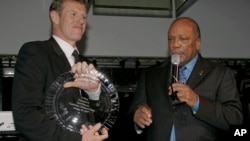 Scott Neeson , left, the Executive Director of The Cambodian Children's Fund, a safe house for Cambodia's orphaned and abused children accepts the inaugural Q prize award from Quincy Jones, right, in New York on Wednesday, Jan. 24, 2007. 