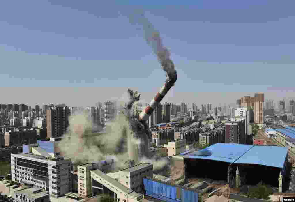A chimney collapses as it is demolished by explosives in Shenyang, Liaoning province, China.