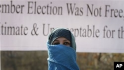 A former legislator, her face covered presumably to obscure her identity, marches during the post-election protest in Kabul, 7 November 2010