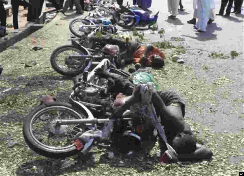 Two bodies of a victim of a suicide bomb lay on the street in Jalingo, Nigeria, Monday, April 30, 2012 amid a row of toppled bikes. A motorcycle-riding suicide bomber drove into a convoy carrying a top police official in northeast Nigeria on Monday, deto