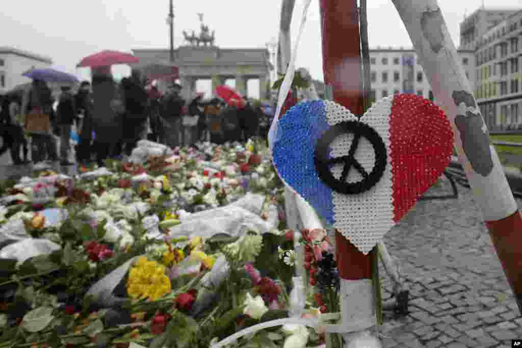 Bunga dan lilin untuk para korban serangan maut di Paris terlihat di depan Kedutaan Besar Perancis dekat Gerbang Brandenburg di Berlin, Jerman (15/11). ​(AP/Markus Schreiber)