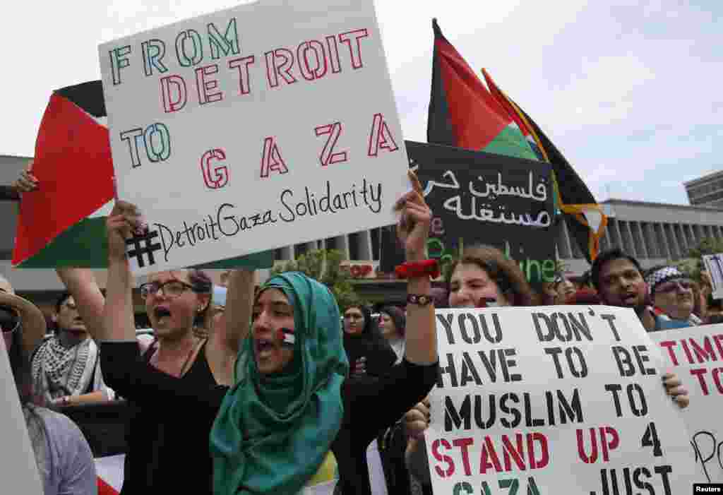 Pengunjuk rasa warga Amerika keturunan Arab memegang poster ketika protes menentang seranga udara militer Israel di Gaza, dalam sebuah demonstrasi di pusat kota Detroit, Michigan, 13 Juli 2014.