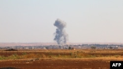 FILE - A picture taken Sept. 1, 2015 shows smoke billowing on the outskirts of Marea in the northern Syrian Aleppo district during fighting between opposition fighters and IS group.