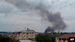 In this photo taken Sunday, July 10, 2016, black smoke is seen rising above the capital Juba, in South Sudan. 