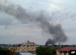In this photo taken Sunday, July 10, 2016, black smoke is seen rising above the capital Juba, in South Sudan.