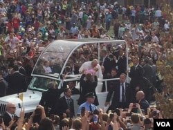 Pope Francis kisses a baby from his popemobile near Independence Hall, Philadelphia, Sept. 26, 2015. (J. Socolovsky/VOA)