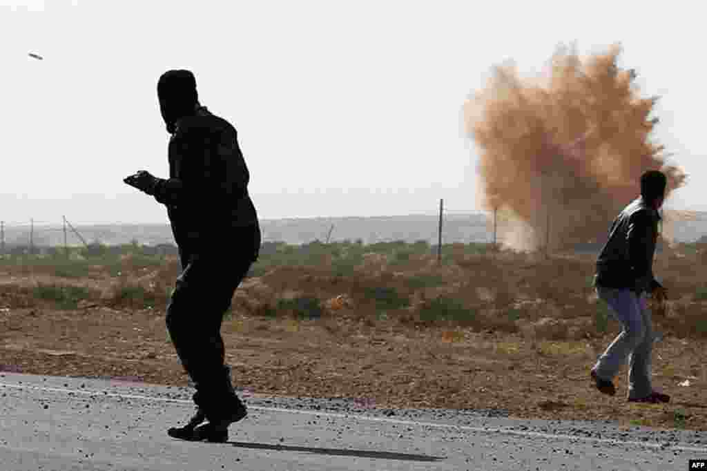 April 1: Rebels run from explosions and an incoming mortar during a barrage fired by troops loyal to Muammar Gaddafi outside Brega in eastern Libya. (Reuters)