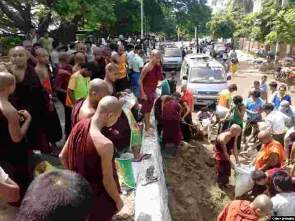 မံုရြာၿမိဳ႕မွာ ေရတားတမံေတြကို ကိုယ္ထူကိုယ္ထ တက္ညီလက္ညီ ပါဝင္လုပ္အားေပးေနတဲ့ မံုရြာၿမိဳ႕သူၿမိဳ႕သားမ်ား။ (ၾသဂုတ္လ ၂၊ ၂၀၁၅/ ဓာတ္ပံု မံုရြာသား)