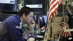 Specialist Gregg Maloney works at his post on the floor of the New York Stock Exchange Thursday, Aug. 18, 2011