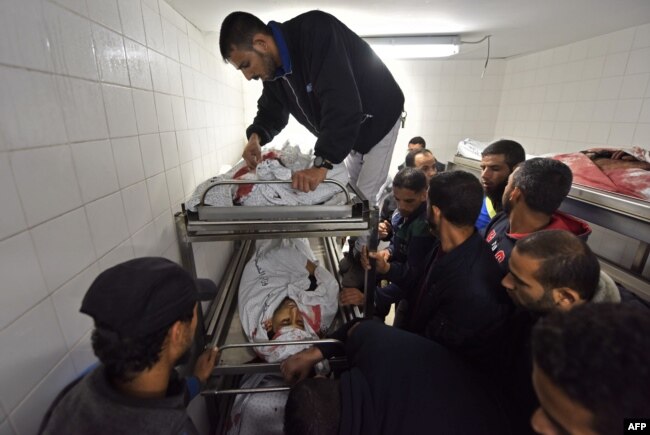 Palestinians gather at a hospital morgue in Khan Younis where the bodies of four of the six men killed during an Israeli raid on the city have been transported, Nov. 11, 2018.