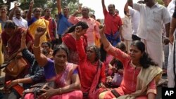 FILE - Protestors block traffic and shout slogans reacting to reports of two women of menstruating age entering the Sabarimala temple, in Thiruvananthapuram, Kerala, India, Jan. 2, 2019.