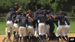 Young baseball players celebrate an extra-innings victory at a sports academy run by the Tampa Bay Rays in Venezuela