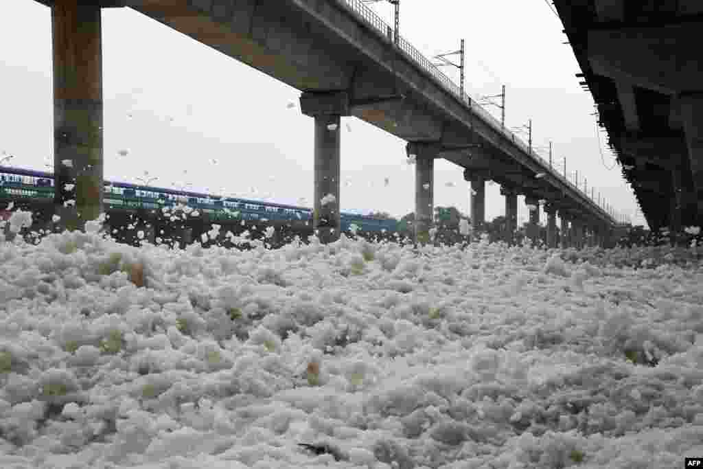 Foam that has gathered in the polluted Yamuna river flies about in the wind in New Delhi, India.