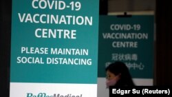 Seorang wanita masuk ke pusat vaksinasi COVID-19 yang baru didirikan yang akan dibuka untuk umum lusa, di Singapura, 26 Januari 2021. (Foto: REUTERS/Edgar Su)