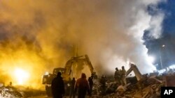 Smoke rises as Donetsk's emergency employees work at a site of a shopping center destroyed following what Russian officials in Donetsk said it was a shelling by Ukrainian forces, in Donetsk, in Russian-controlled Donetsk region, Jan. 16, 2023. 