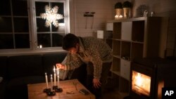 The Rev. Siv Limstrand lights candles at the church's cabin in Bolterdalen, Norway, Jan. 9, 2023. The cabin is used for retreats and church groups.