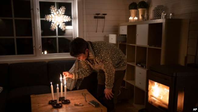 The Rev. Siv Limstrand lights candles at the church's cabin in Bolterdalen, Norway, Jan. 9, 2023. The cabin is used for retreats and church groups.