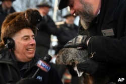 Groundhog Club handler A.J. Dereume holds Punxsutawney Phil, the weather prognosticating groundhog, while talking with WTAJ Meteorologist Joe Murgo during the 137th celebration of Groundhog Day on Gobbler's Knob in Punxsutawney, Pa., Feb. 2, 2023