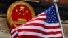 Bendera Amerika Serikat berkibar di sebelah lambang nasional China saat upacara penyambutan di Aula Besar Rakyat di Beijing, 9 November 2017. (Foto: AP)