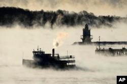 Arctic sea smoke rises from the the Atlantic Ocean as a passenger ferry passes Spring Point Ledge Light, Feb. 4, 2023, off the coast of South Portland, Maine. The morning temperature was about -10 degrees Fahrenheit.