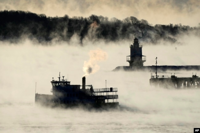 Arctic sea smoke rises from the the Atlantic Ocean as a passenger ferry passes Spring Point Ledge Light, Feb. 4, 2023, off the coast of South Portland, Maine. The morning temperature was about -10 degrees Fahrenheit.