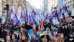 Protestors wave flags during a rally, called by left-wing La France Insoumise (LFI) party and Youth organizations, to protest against the French President's pension reform, in Paris, Jan. 21, 2023.