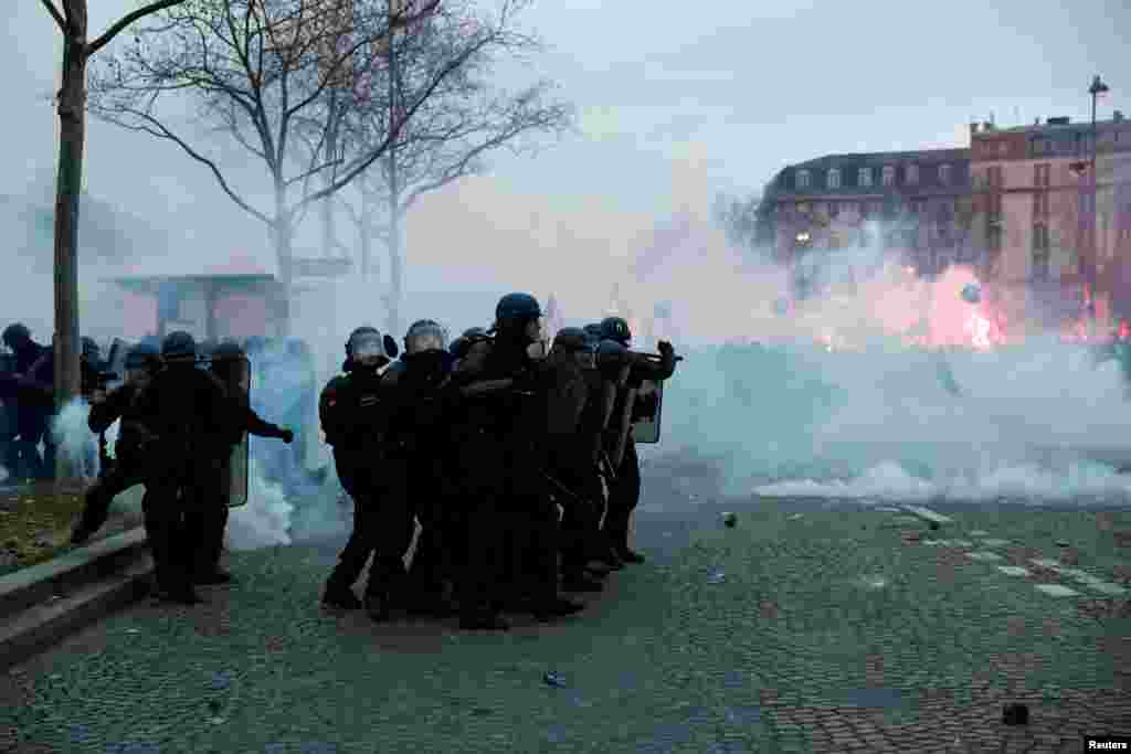 French police hold their position amid clashes with protesters in Paris near the Invalides during a national strike against the French government&#39;s pension reform plan.