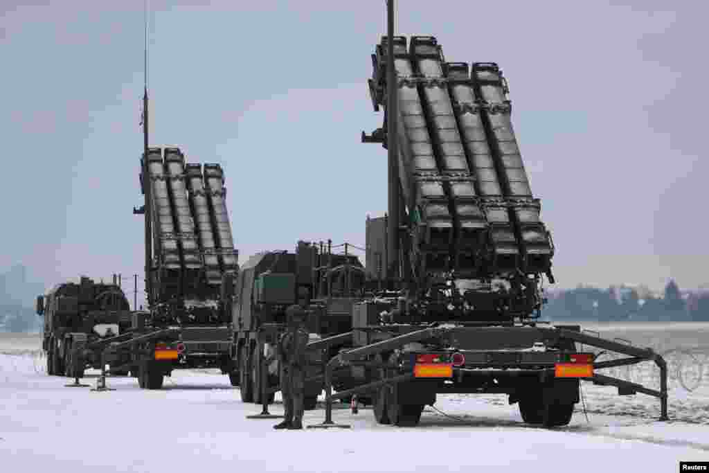 Serviceman patrols in front of the Patriot air defense system during Polish military training on the missile systems at the airport in Warsaw, Feb. 7, 2023.