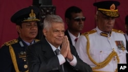 Sri Lankan president Ranil Wickremesinghe, front left, greets children as airforce commander during the 75th Independence Day ceremony in Colombo, Sri Lanka, Feb. 4, 2023.