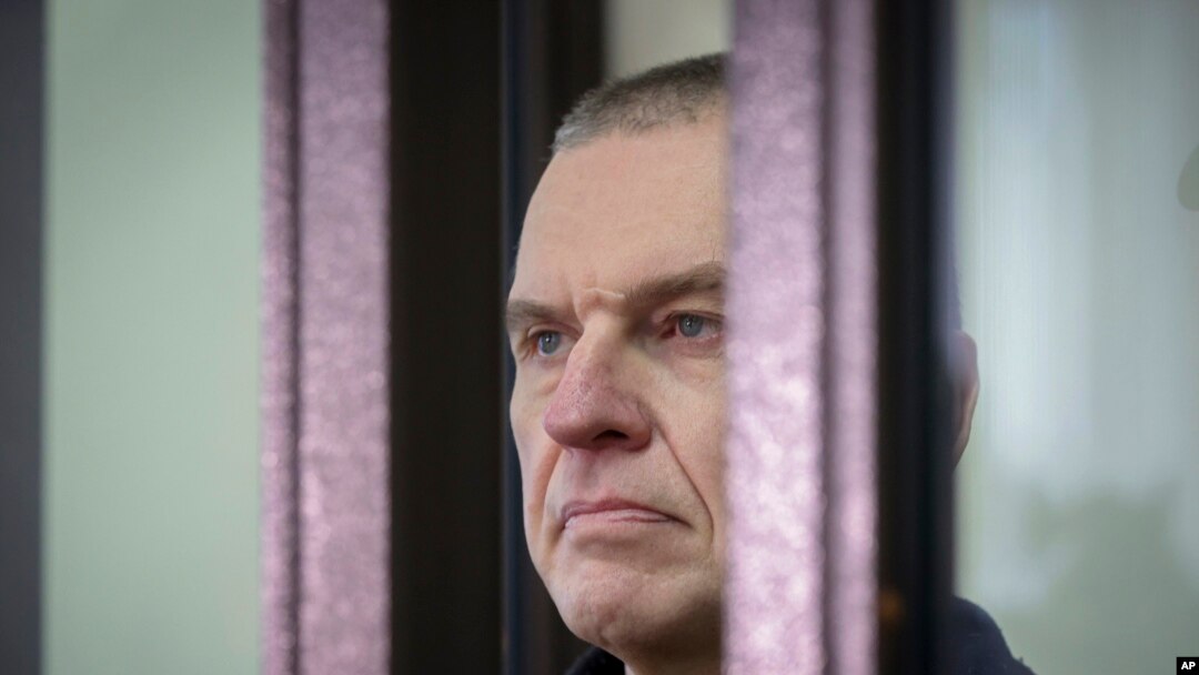 FILE - Journalist Andrzej Poczobut stands in a defendants' cage during a court session in Grodno, Belarus, Jan. 16, 2023. 