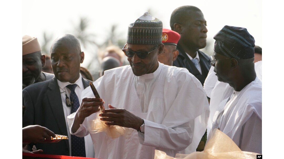 Nigeria's President, Muhammadu Buhari, center, prepare to cut the ribbon to Commission the Lekki deep seaport in Lagos, Jan. 23, 2023.