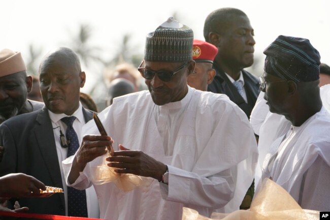 Nigeria's President, Muhammadu Buhari, center, prepare to cut the ribbon to Commission the Lekki deep seaport in Lagos, Jan. 23, 2023.