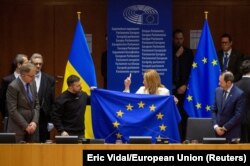 Presiden Parlemen Eropa Roberta Metsola memegang bendera Uni Eropa bersama Presiden Ukraina Volodymyr Zelenskiy di Parlemen Eropa di Brussels, Belgia 9 Februari 2023.