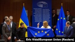 Presiden Parlemen Eropa Roberta Metsola memegang bendera Uni Eropa bersama Presiden Ukraina Volodymyr Zelenskyy di Parlemen Eropa di Brussels, Belgia 9 Februari 2023. (Foto: Eric Vidal via REUTERS)