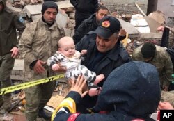 Seorang bayi diselamatkan dari bangunan yang hancur di Malatya, Turki, 6 Februari 2023. (DIA Images via AP)