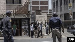 Des agents des services de police sud-africains (SAPS) en patrouille dans le quartier central des affaires de Johannesburg lors des troubles du 16 janvier 2023,