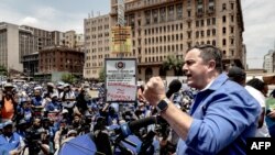 The leader of South Africa's opposition Democratic Alliance John Steenhuisen (R) addresses supporters during their protest as they marched towards the ruling African National Congress's headquarters, Luthuli House, to hand in a memorandum.