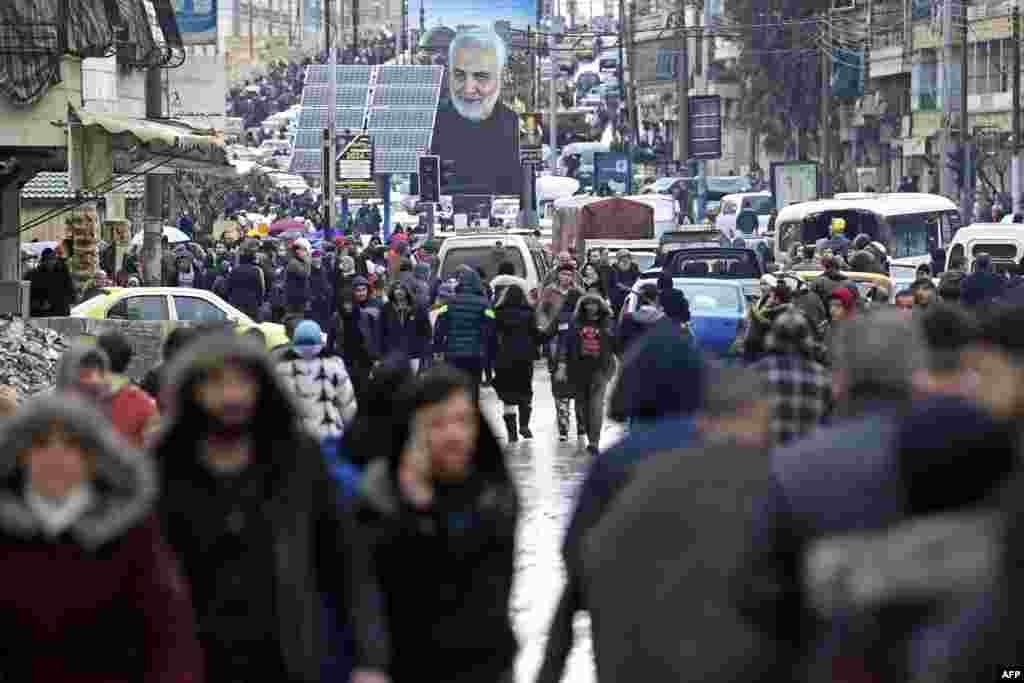 People evacuate their homes following a deadly earthquake that shook Syria at dawn, Feb. 6, 2023 in Aleppo's Salaheddine district. Poster in the background shows slain Iranian commander Qasem Soleiman.