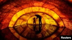 FILE - A woman and her daughter touch a model of the earth's core at Nanjing Geological Museum in Nanjing, Jiangsu province April 22, 2011. (REUTERS/Sean Yong)