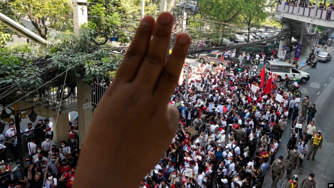 Myanmar nationals living in Thailand display the three-finger symbol of resistance during a protest marking the anniversary of the military takeover that ousted their government outside the Myanmar Embassy in Bangkok, Thailand, Feb. 1, 2023.