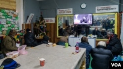 Local residents watch television in a bunker as artillery flies in and out of the area, in Bakhmut, Ukraine, Jan. 20, 2023. (Yan Boechat/VOA)