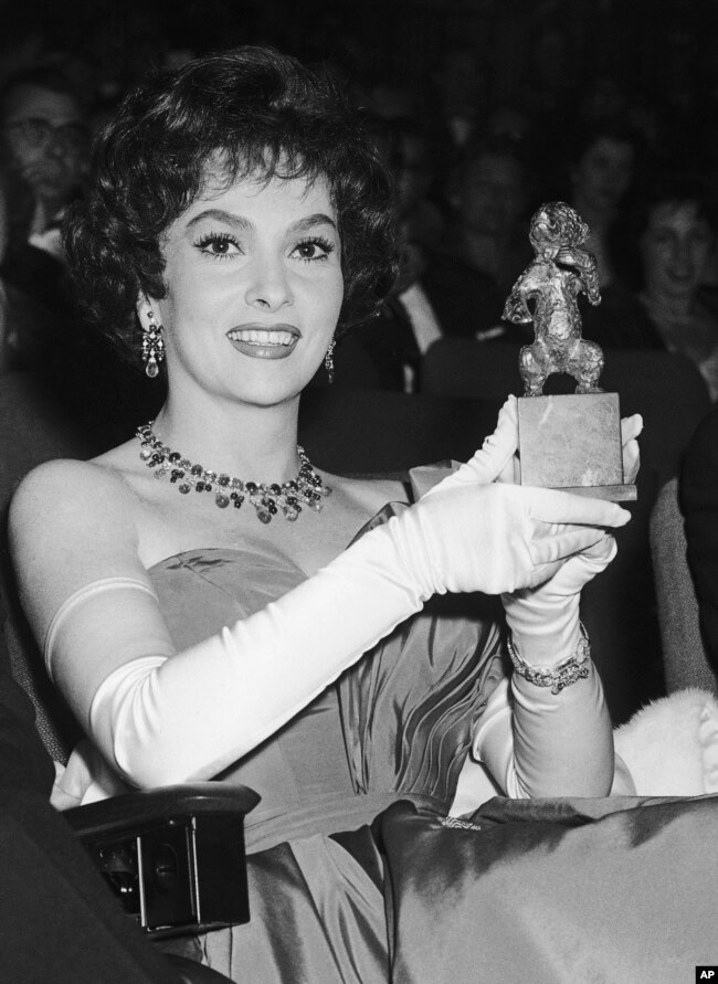 FILE - Italian actress Gina Lollobrigida shows the Silver Bear Award she accepted on behalf of her 'dearest friend' Anna Magnani during the prize giving ceremony at the end of West Berlin's 36-nation Film Festival, July 8, 1958.