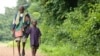 (FILE) A boy helps a man who was blinded by the Neglected Tropical Disease onchocerciasis, or river blindness.